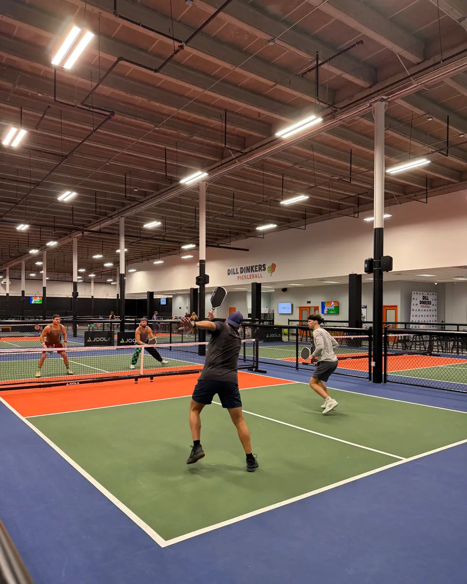 Players in a doubles game at Dill Dinkers Salisbury with the club sign in the background